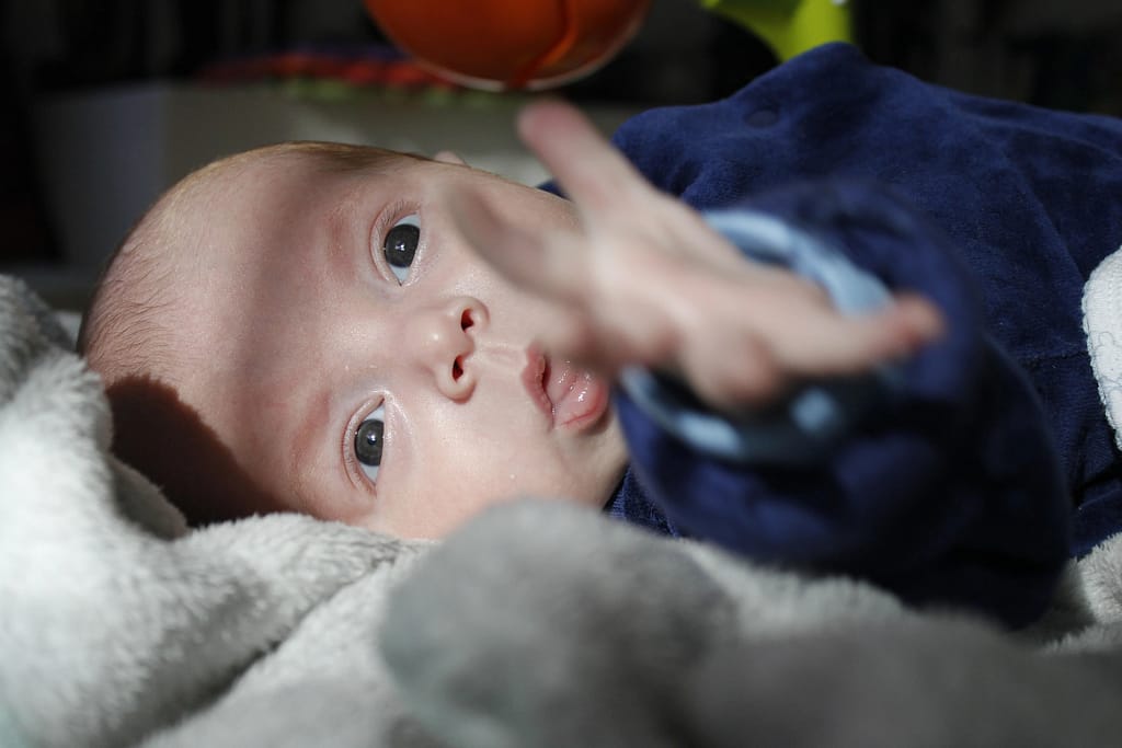 A six-month-old premature baby looks at the camera, eyes wide open, seizure attack in babies