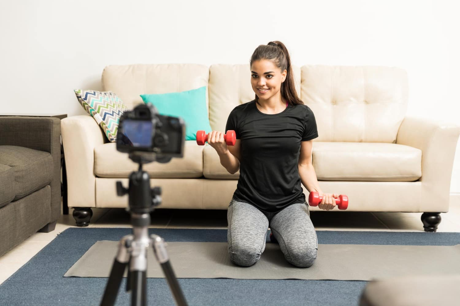 Pretty young hispanic fitness blogger working out on camera and giving some advice to viewers - 4-week workout plan for weight loss female