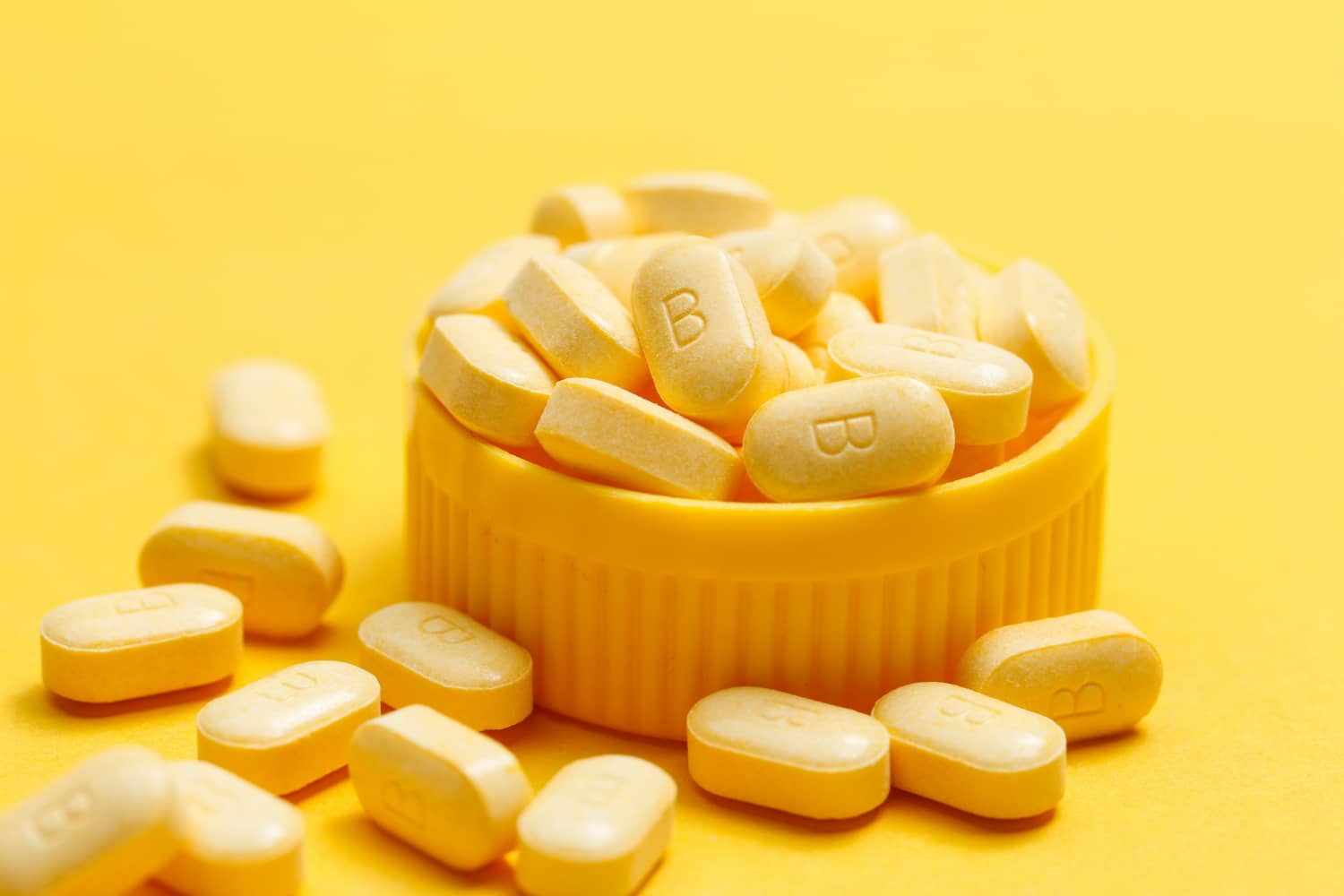 Vitamin b tablets on yellow background